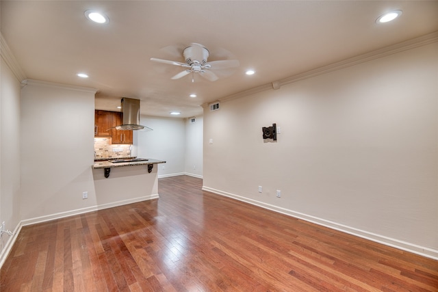 unfurnished living room featuring ceiling fan, wood-type flooring, and ornamental molding