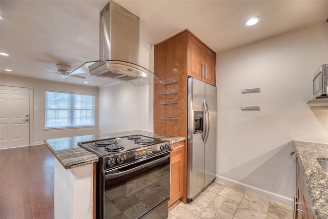 kitchen featuring electric range, light hardwood / wood-style floors, stainless steel refrigerator with ice dispenser, ceiling fan, and island exhaust hood