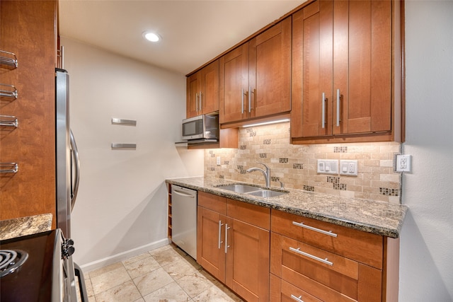 kitchen with stainless steel appliances, tasteful backsplash, sink, stone countertops, and light tile patterned floors