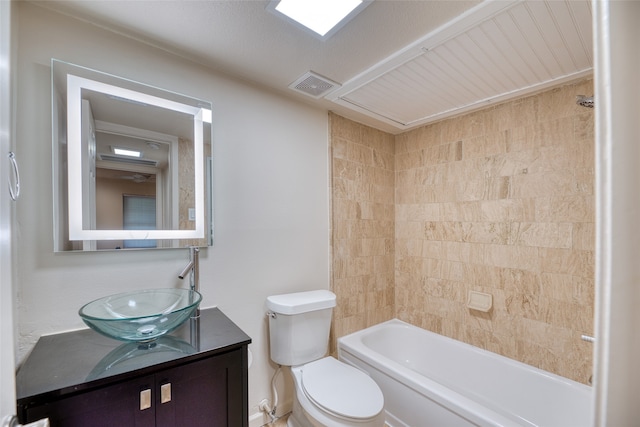 full bathroom with vanity, tiled shower / bath combo, and toilet