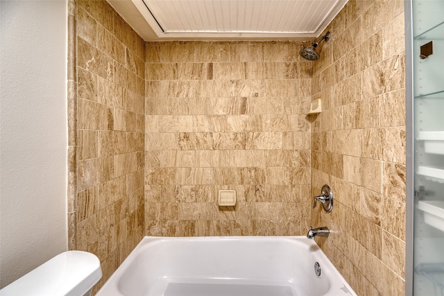 bathroom featuring tiled shower / bath combo and toilet