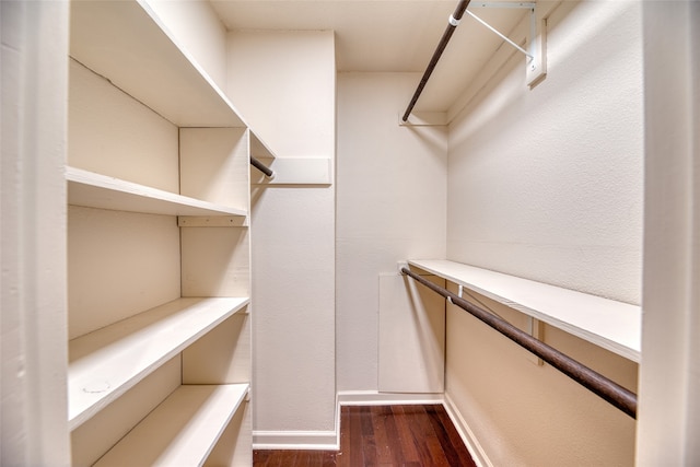 walk in closet with dark wood-type flooring