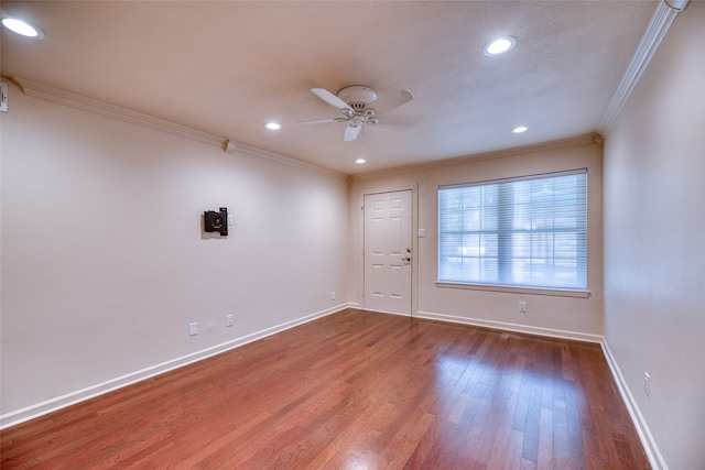 empty room featuring ceiling fan, ornamental molding, and wood-type flooring