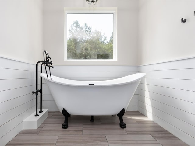 bathroom with a tub to relax in and tile patterned flooring