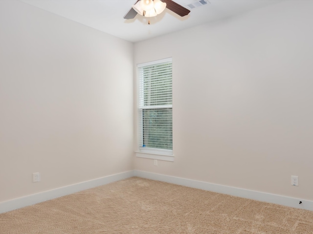 carpeted spare room featuring ceiling fan and plenty of natural light