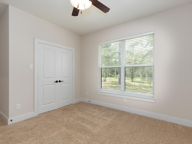 unfurnished bedroom featuring ceiling fan, a closet, and carpet floors