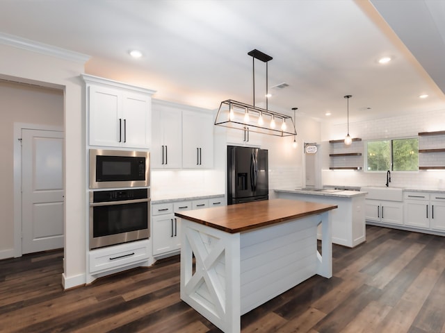 kitchen with stainless steel appliances, tasteful backsplash, white cabinets, dark hardwood / wood-style flooring, and a center island