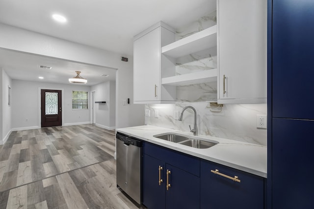 kitchen with stainless steel dishwasher, light hardwood / wood-style flooring, tasteful backsplash, blue cabinetry, and sink