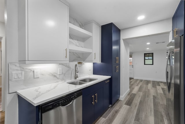 kitchen with light hardwood / wood-style floors, blue cabinets, sink, and stainless steel appliances