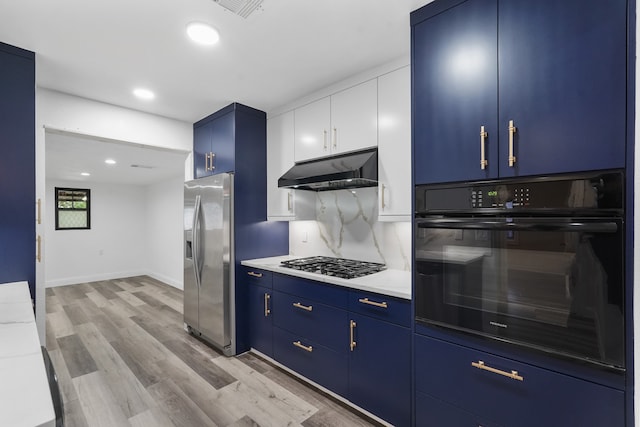 kitchen with appliances with stainless steel finishes, tasteful backsplash, light wood-type flooring, white cabinets, and blue cabinets