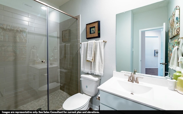 bathroom with vanity, toilet, and a shower with shower door