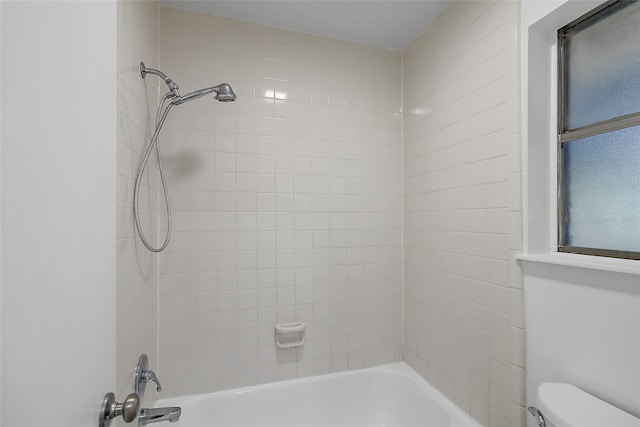 bathroom with tiled shower / bath and toilet