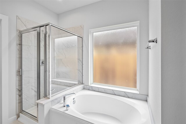 bathroom with a shower stall and a bath