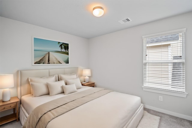 carpeted bedroom with visible vents and baseboards