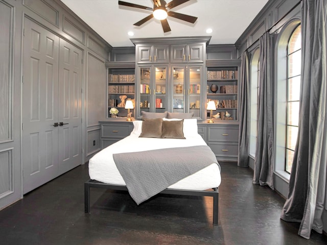 bedroom featuring ceiling fan, crown molding, a closet, and dark hardwood / wood-style flooring