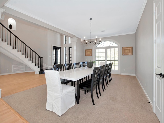 dining room with light wood-type flooring, an inviting chandelier, and ornamental molding