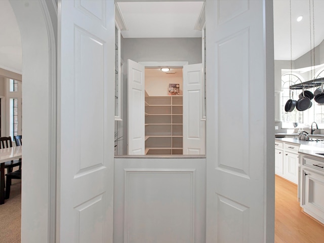 interior space featuring sink, white cabinetry, and light wood-type flooring