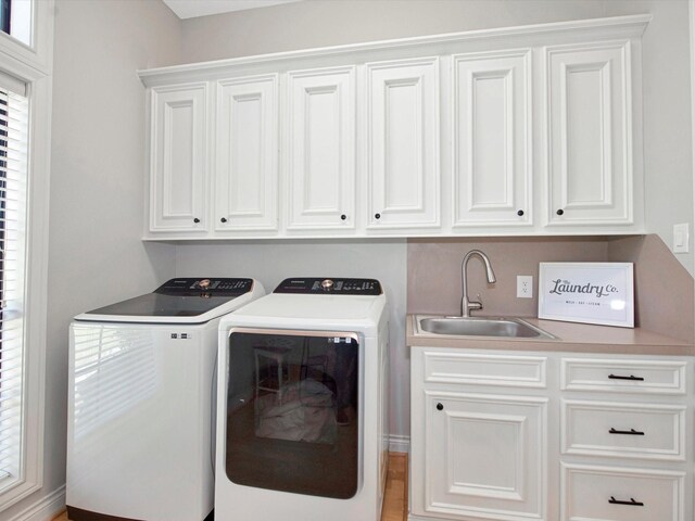 laundry area with sink, washer and dryer, and cabinets