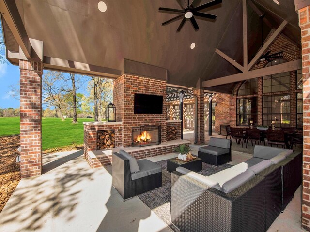 view of patio / terrace with ceiling fan and an outdoor living space with a fireplace