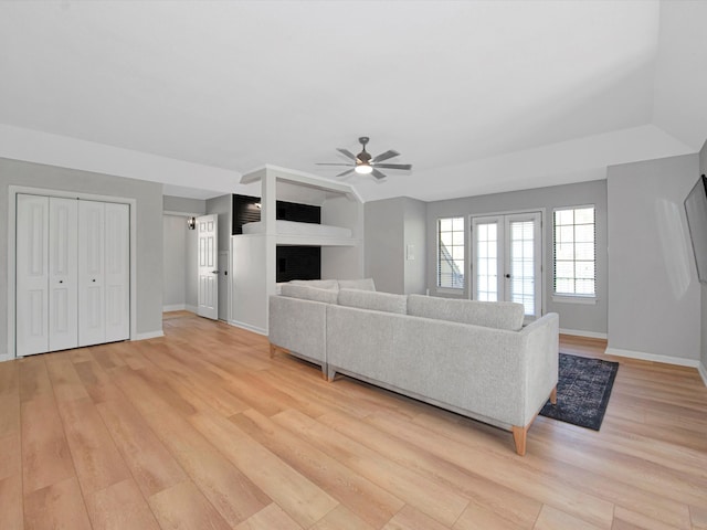 unfurnished living room with a fireplace, ceiling fan, and light hardwood / wood-style floors