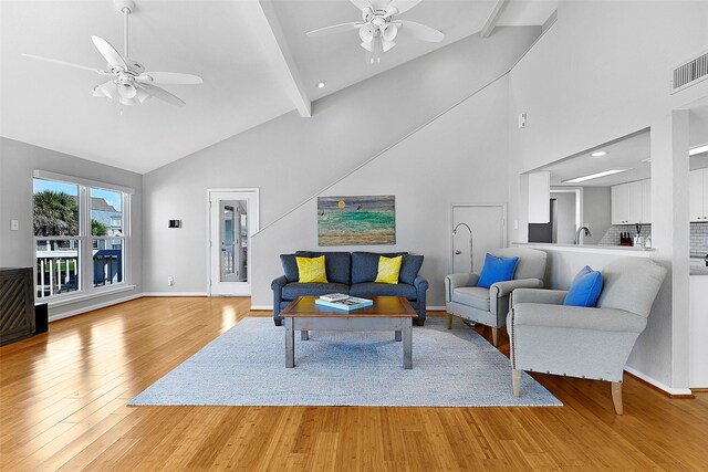 living room featuring ceiling fan, beam ceiling, high vaulted ceiling, and hardwood / wood-style floors