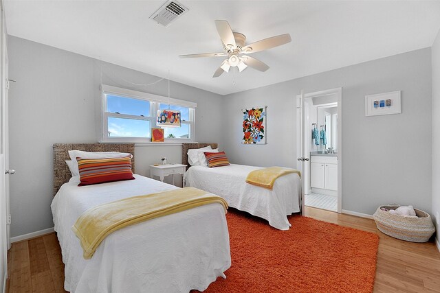 bedroom featuring ceiling fan, ensuite bathroom, and hardwood / wood-style floors