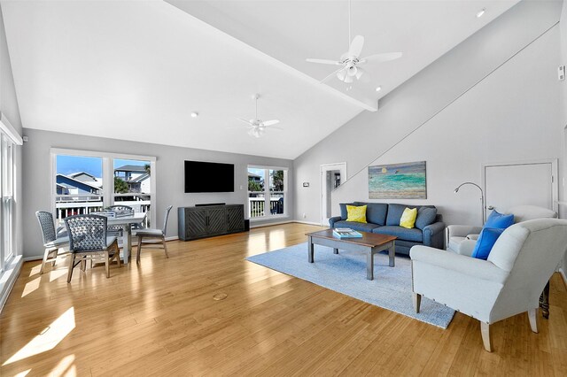 living room with ceiling fan, high vaulted ceiling, and light hardwood / wood-style flooring