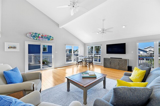 living room with ceiling fan, high vaulted ceiling, and light hardwood / wood-style flooring