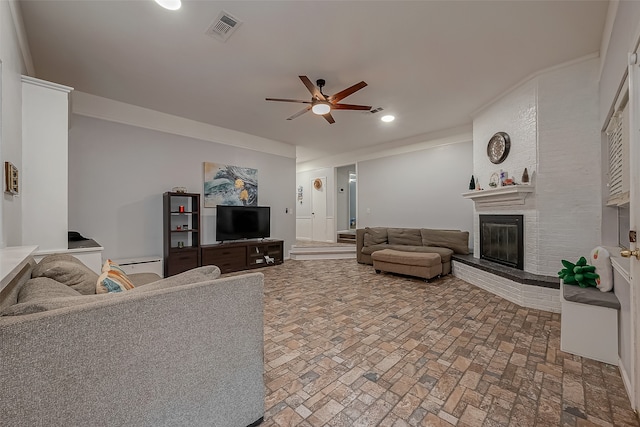 living room with ceiling fan, a fireplace, and crown molding