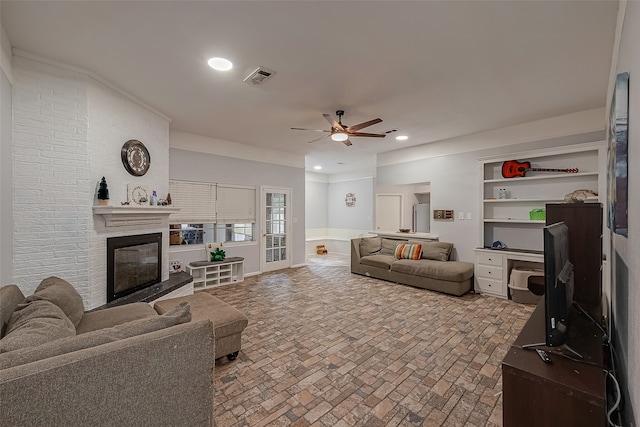 living room featuring ceiling fan and a brick fireplace