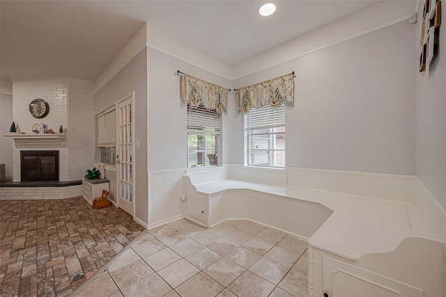 bathroom featuring a bathtub, a brick fireplace, and brick wall