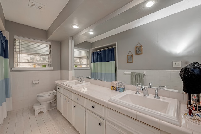 bathroom featuring toilet, tile walls, tile patterned flooring, and vanity