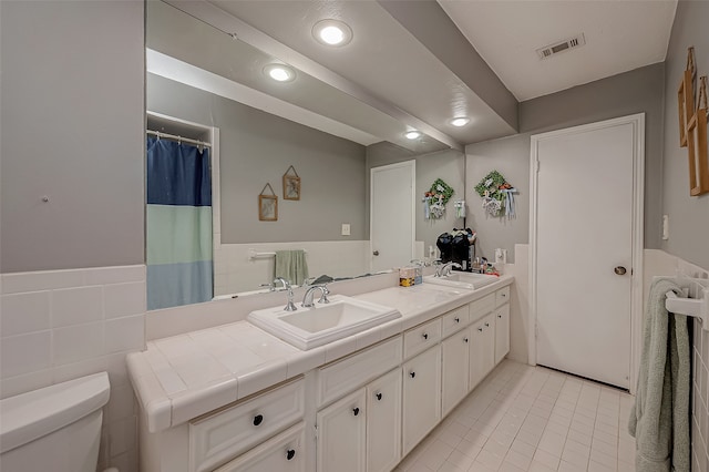 bathroom featuring tile walls, tile patterned flooring, vanity, and toilet