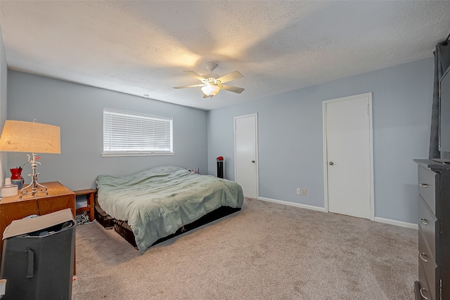 carpeted bedroom featuring ceiling fan and a textured ceiling