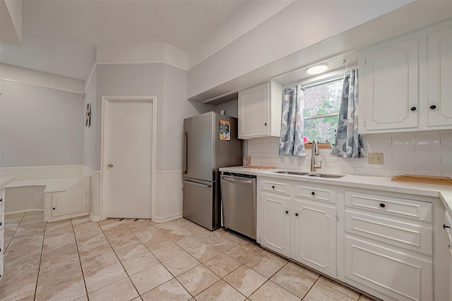 kitchen with white cabinetry, backsplash, and stainless steel appliances