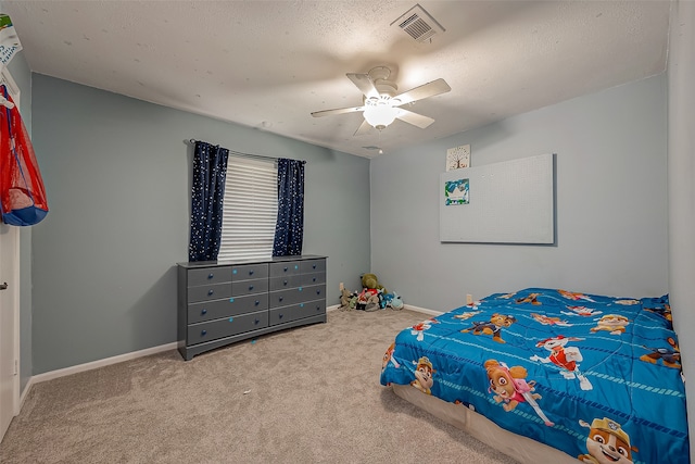 carpeted bedroom featuring ceiling fan and a textured ceiling