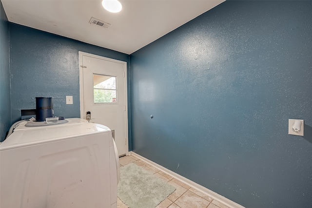 laundry area with washer / clothes dryer and light tile patterned flooring