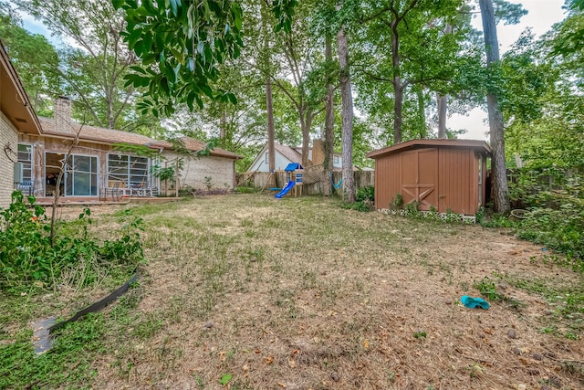 view of yard with a playground and a storage unit