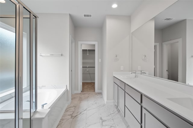 bathroom with a washtub, vanity, and plenty of natural light