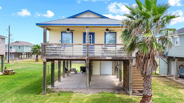 rear view of property featuring a yard and ceiling fan