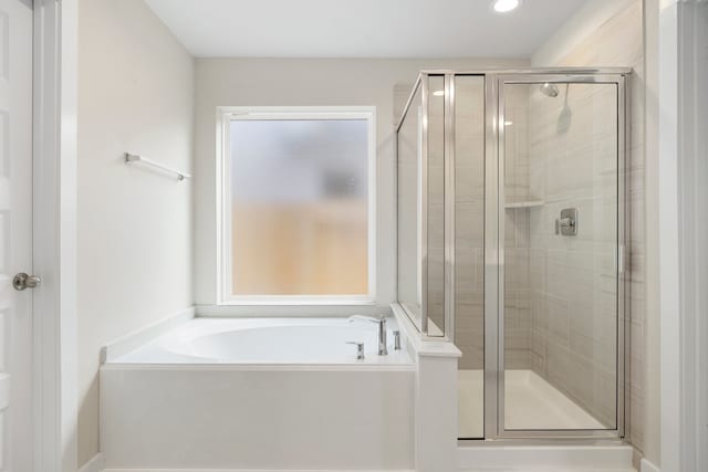 bathroom featuring shower with separate bathtub