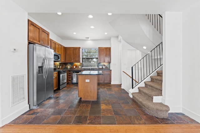 kitchen featuring a center island, sink, stainless steel appliances, and tasteful backsplash