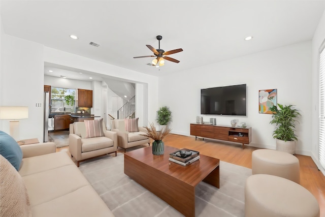 living room featuring ceiling fan and light hardwood / wood-style flooring