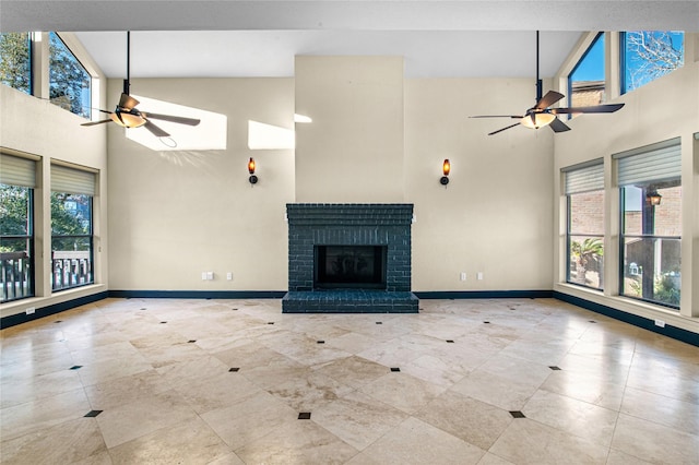 unfurnished living room featuring ceiling fan, a fireplace, and high vaulted ceiling