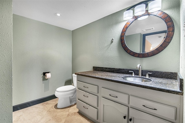 bathroom featuring tile patterned floors, vanity, and toilet