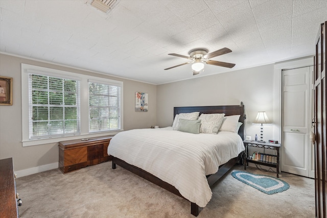 bedroom with ceiling fan and light carpet