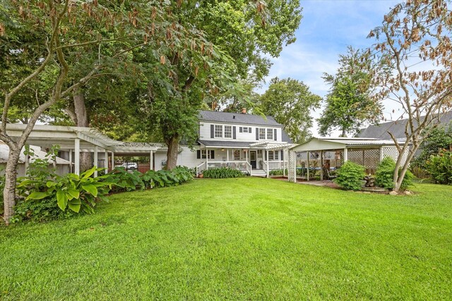 rear view of property featuring a lawn and a pergola