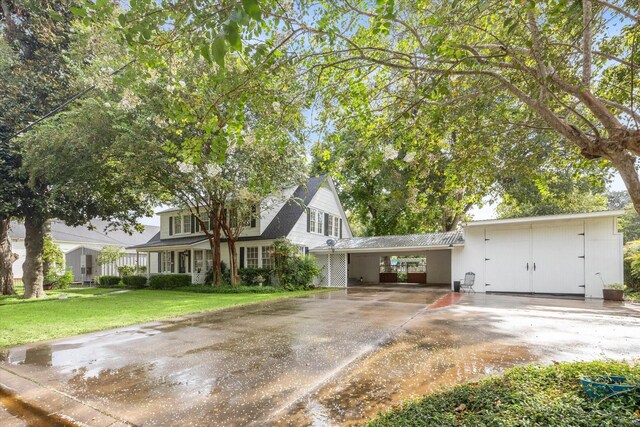 view of front of property featuring a front lawn and a carport