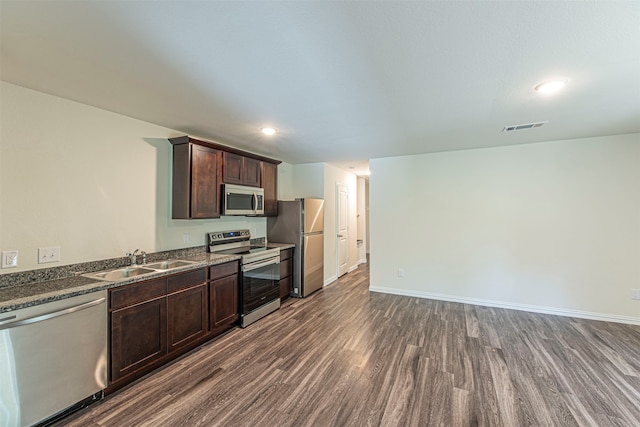 kitchen featuring appliances with stainless steel finishes, dark wood-type flooring, sink, and dark brown cabinetry