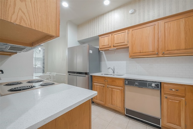 kitchen with light tile patterned flooring, sink, dishwashing machine, decorative backsplash, and stainless steel fridge